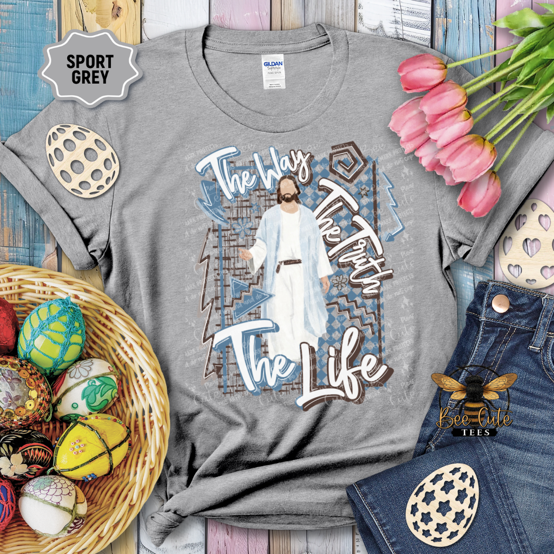 Gray t-shirt with graphic design and text, surrounded by Easter decorations on a wooden surface.