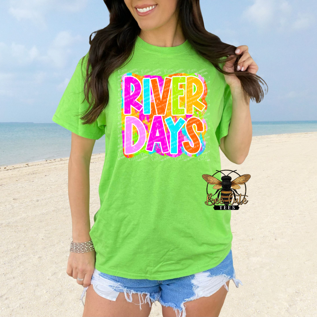 Person wearing a bright green 'River Days' t-shirt on a beach