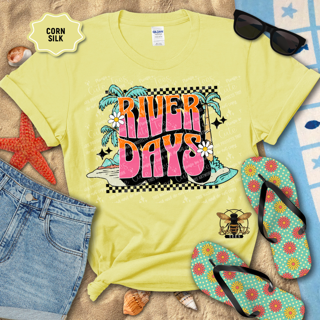Yellow t-shirt with 'River Days' design, sunglasses, flip-flops, and denim shorts on a sandy background.