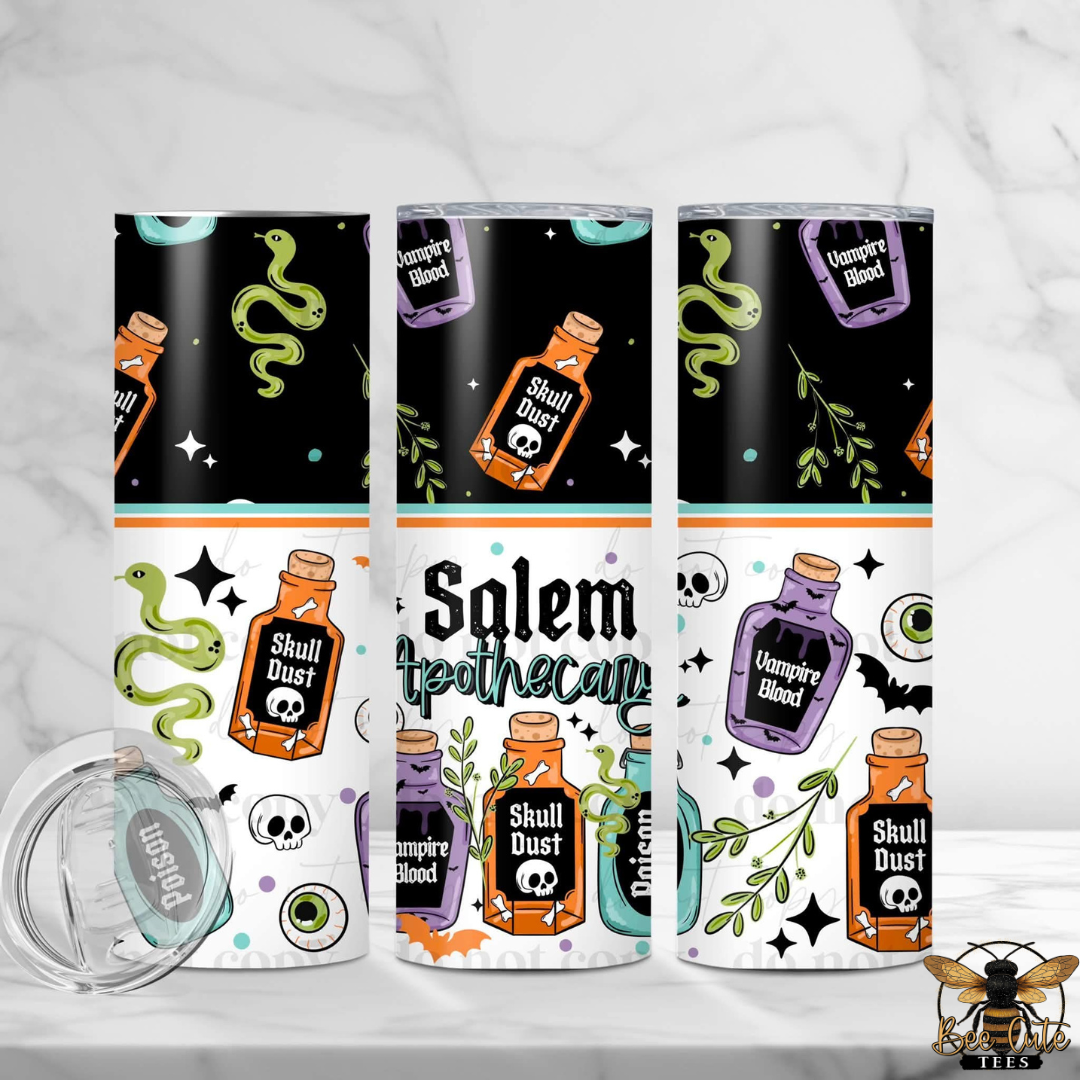 Three slim stainless steel tumblers with Halloween-themed wraparound prints are displayed on a white marble surface. The designs feature black upper sections with green snakes, orange potion bottles labeled 'Soul Dust' and 'Halloween Blood,' white lower sections with skulls, green leaves, and the words 'Salem Apothecary,' plus a separate clear lid shown in the lower left.