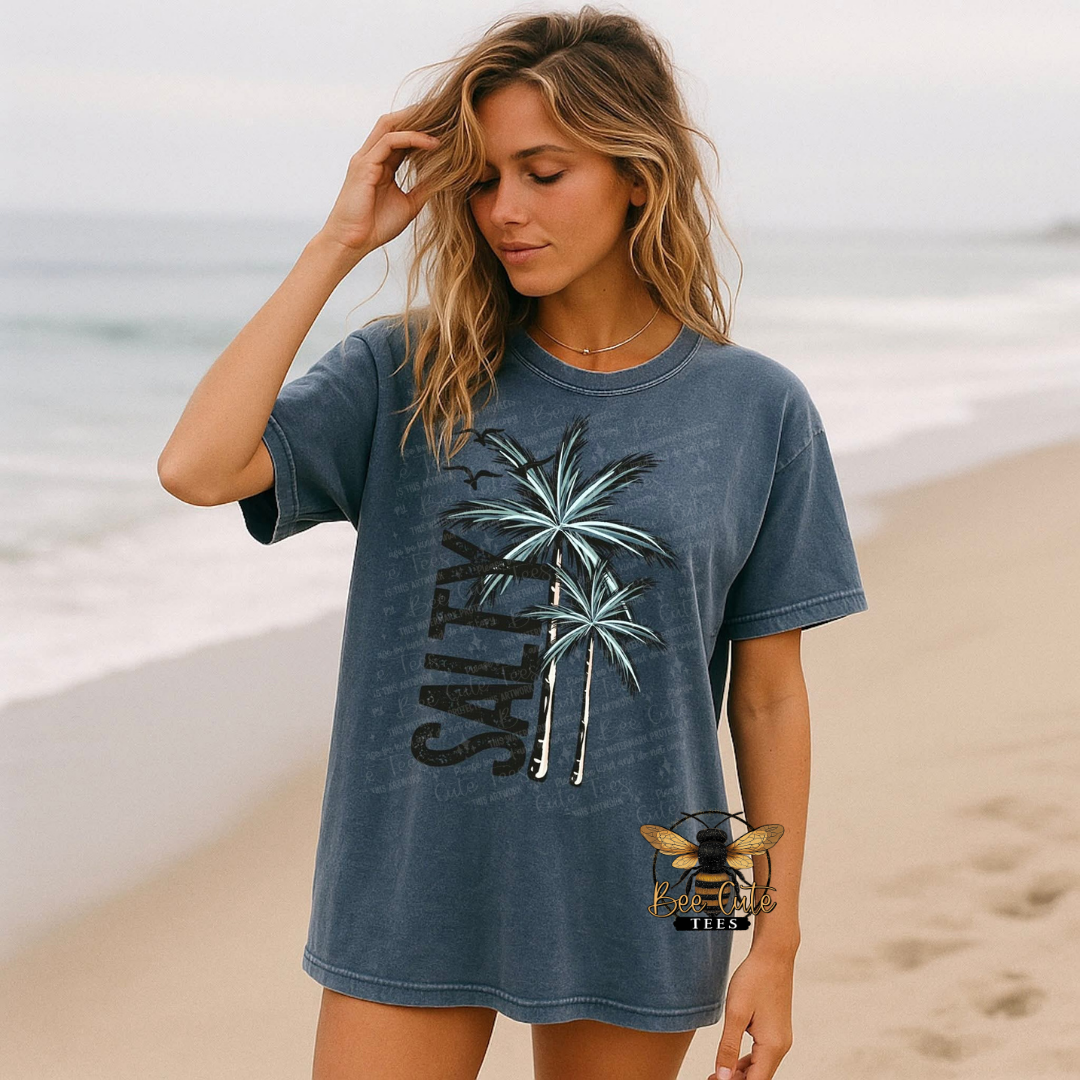 Woman wearing a blue t-shirt with palm tree design on a beach