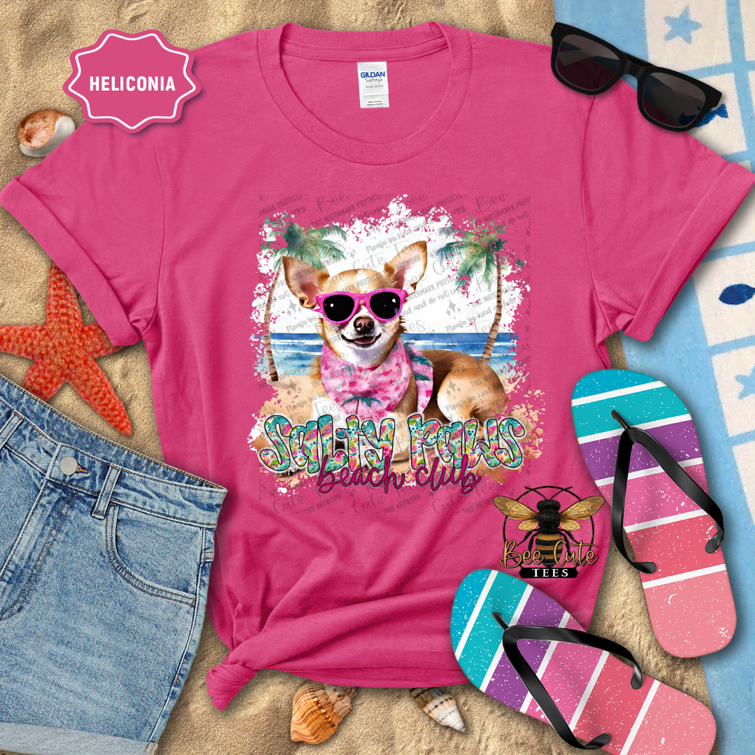Pink t-shirt with a dog graphic and 'Beach Club' text, surrounded by beach accessories.