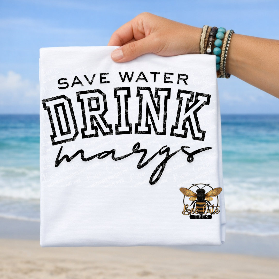 Hand holding a t-shirt with 'Save Water Drink Margaritas' text against a beach background