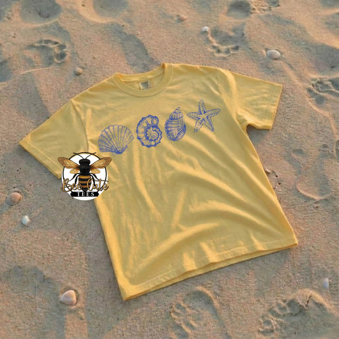 Yellow t-shirt with beach-themed designs on sand