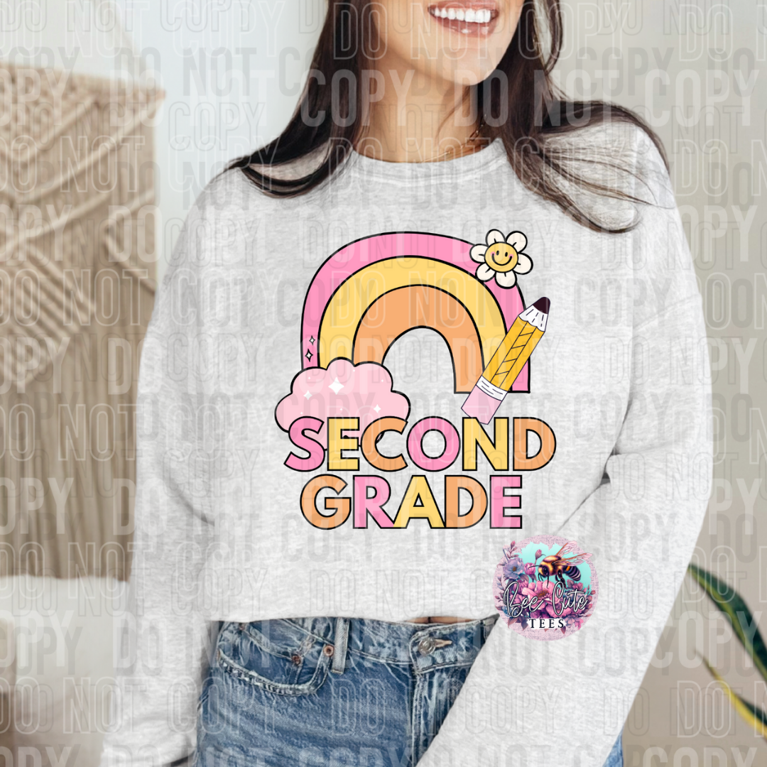 Person wearing a sweatshirt with a 'Second Grade' design featuring a rainbow and pencil.