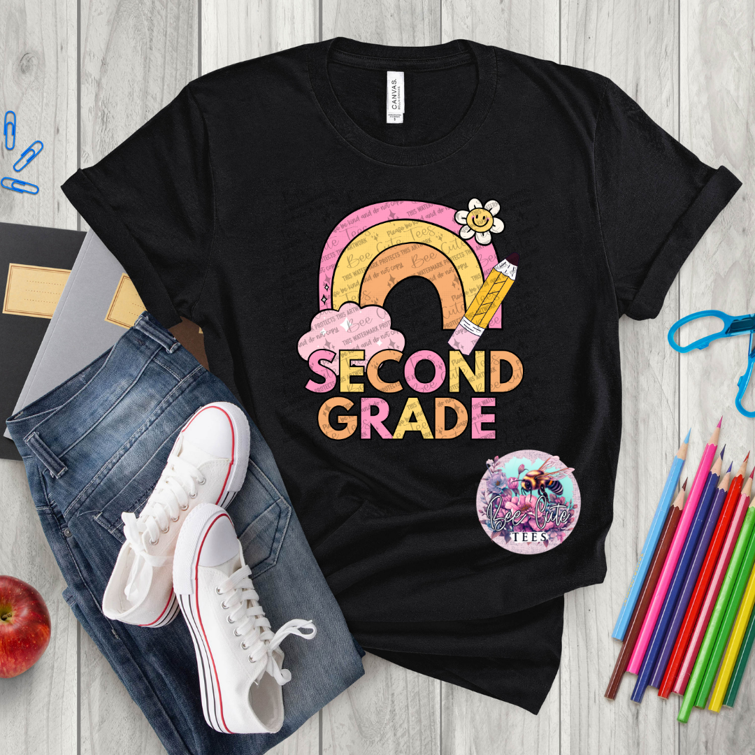 Black t-shirt with 'Second Grade' design on a wooden surface with school supplies.