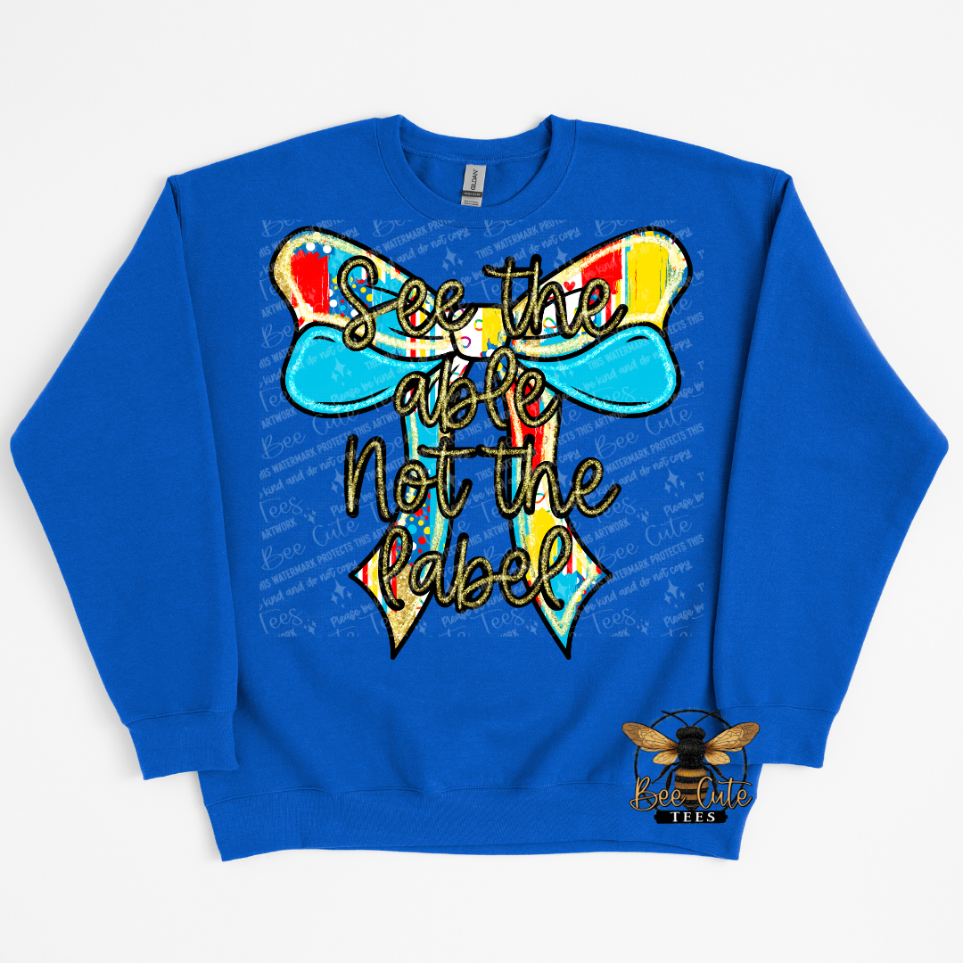 Blue sweatshirt with colorful bow design and text on a white background