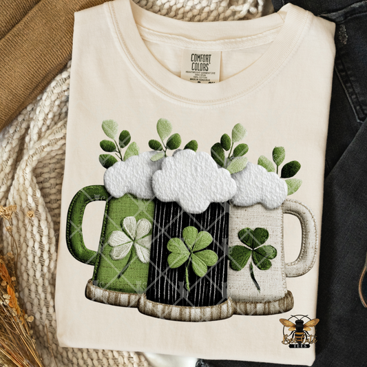 Beige sweatshirt with beer mugs and shamrocks design on a textured surface