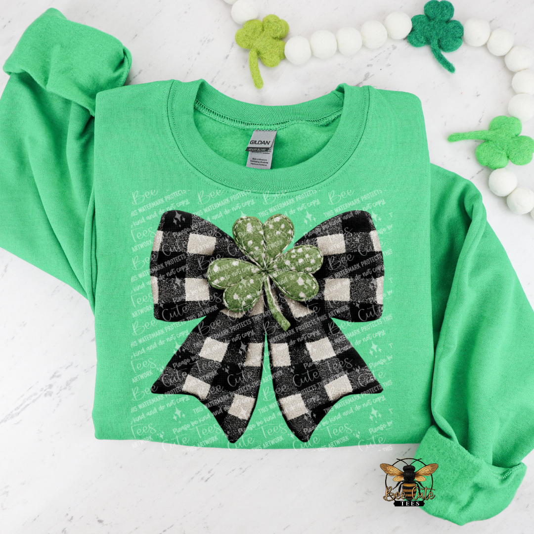 Green sweatshirt with a black and white checkered bow and shamrock design on a white background.