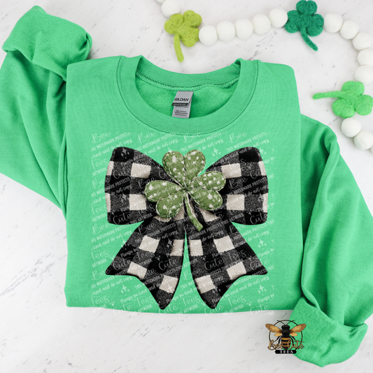 Green sweatshirt with a black and white checkered bow and shamrock design on a white background.