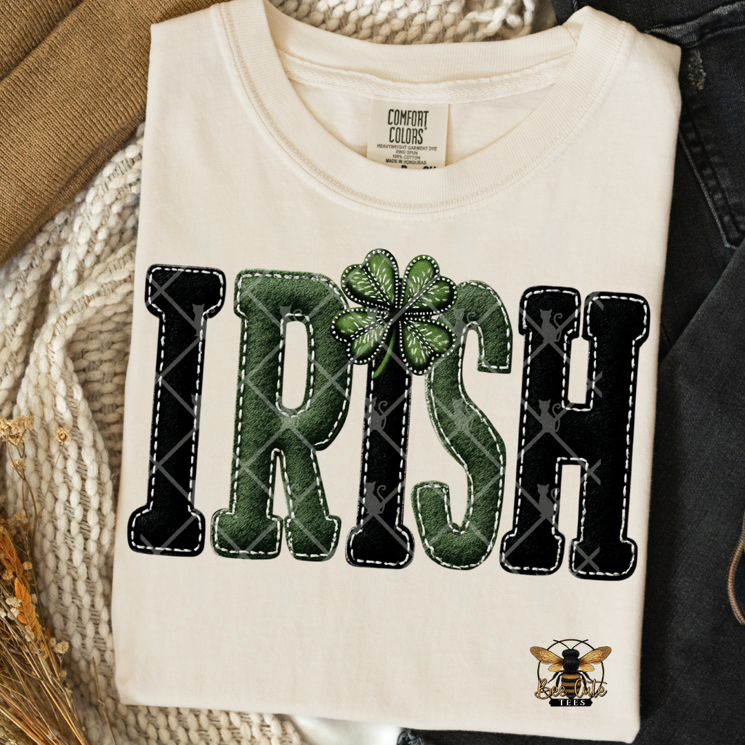 White t-shirt with 'IRISH' text and clover leaf design on a textured surface.