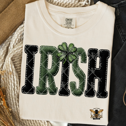 White t-shirt with 'IRISH' text and clover leaf design on a textured surface.