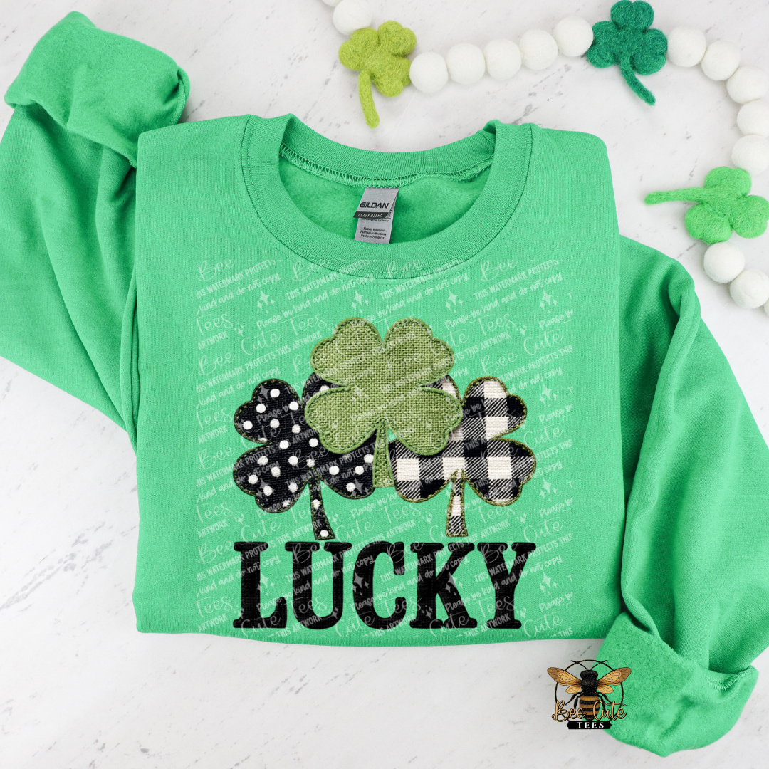 Green sweatshirt with shamrock design and 'LUCKY' text on a white background