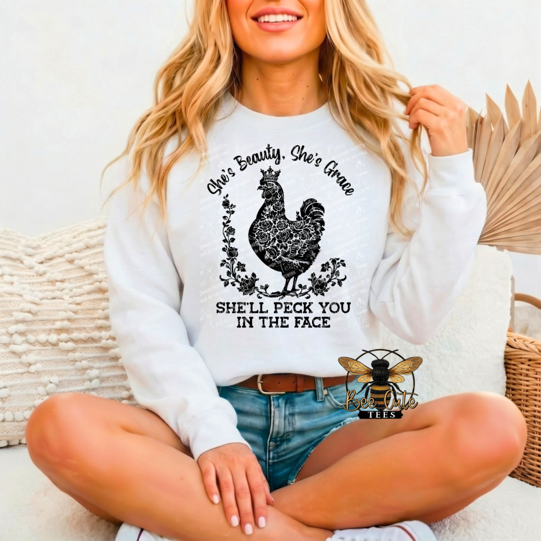 Woman wearing a white sweatshirt with a graphic design and text, sitting on a couch.