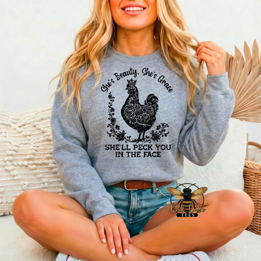 Woman wearing a gray sweatshirt with a chicken graphic and text, sitting on a couch.