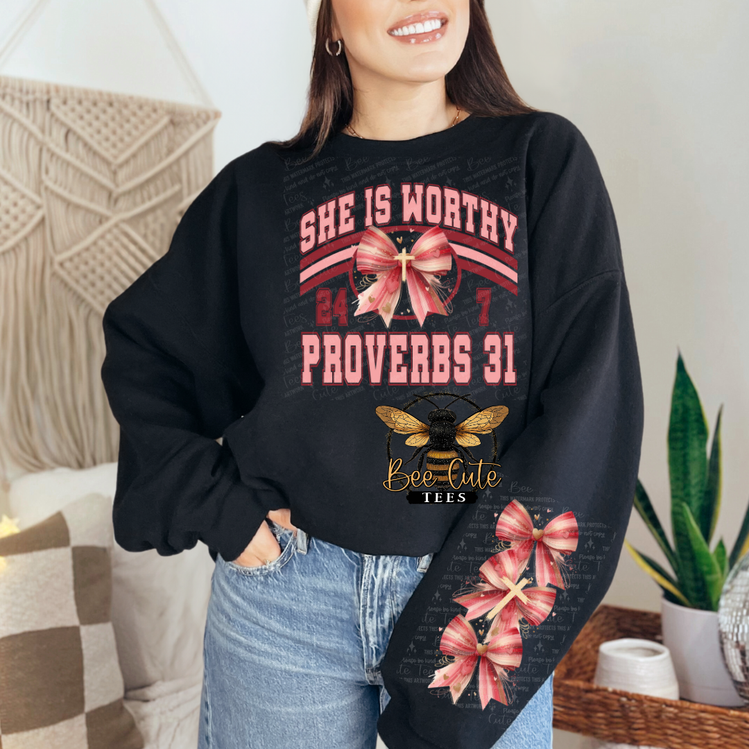 Person wearing a black sweatshirt with decorative text and graphics, standing in a home setting.