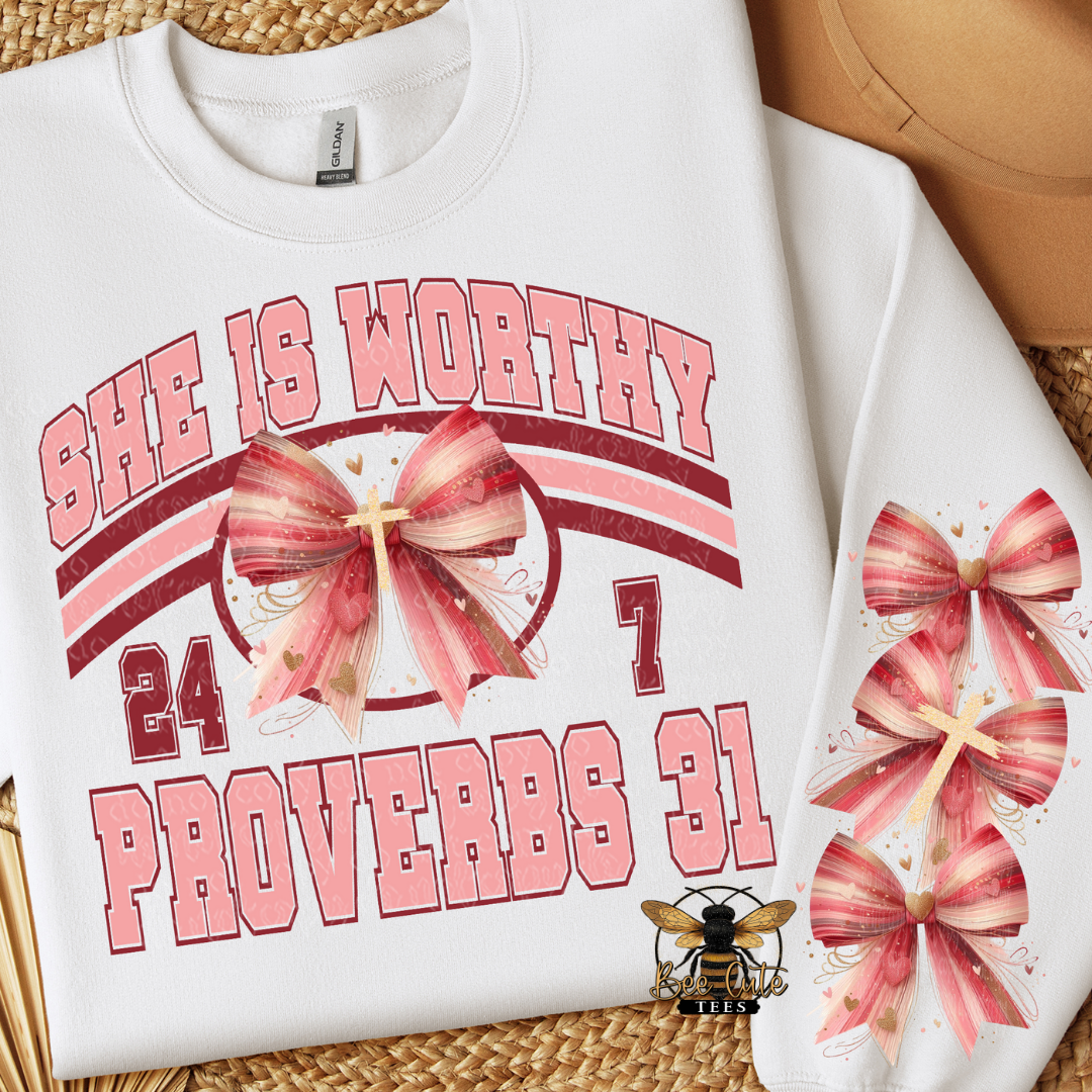 White sweatshirt with pink text and graphics on a woven surface