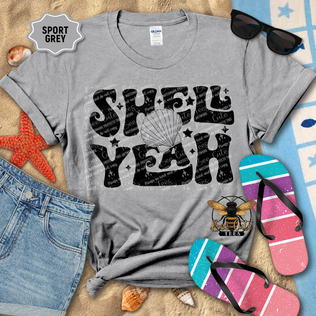Gray t-shirt with 'Shell Yeah' design on a beach-themed background with sunglasses, flip-flops, and starfish.