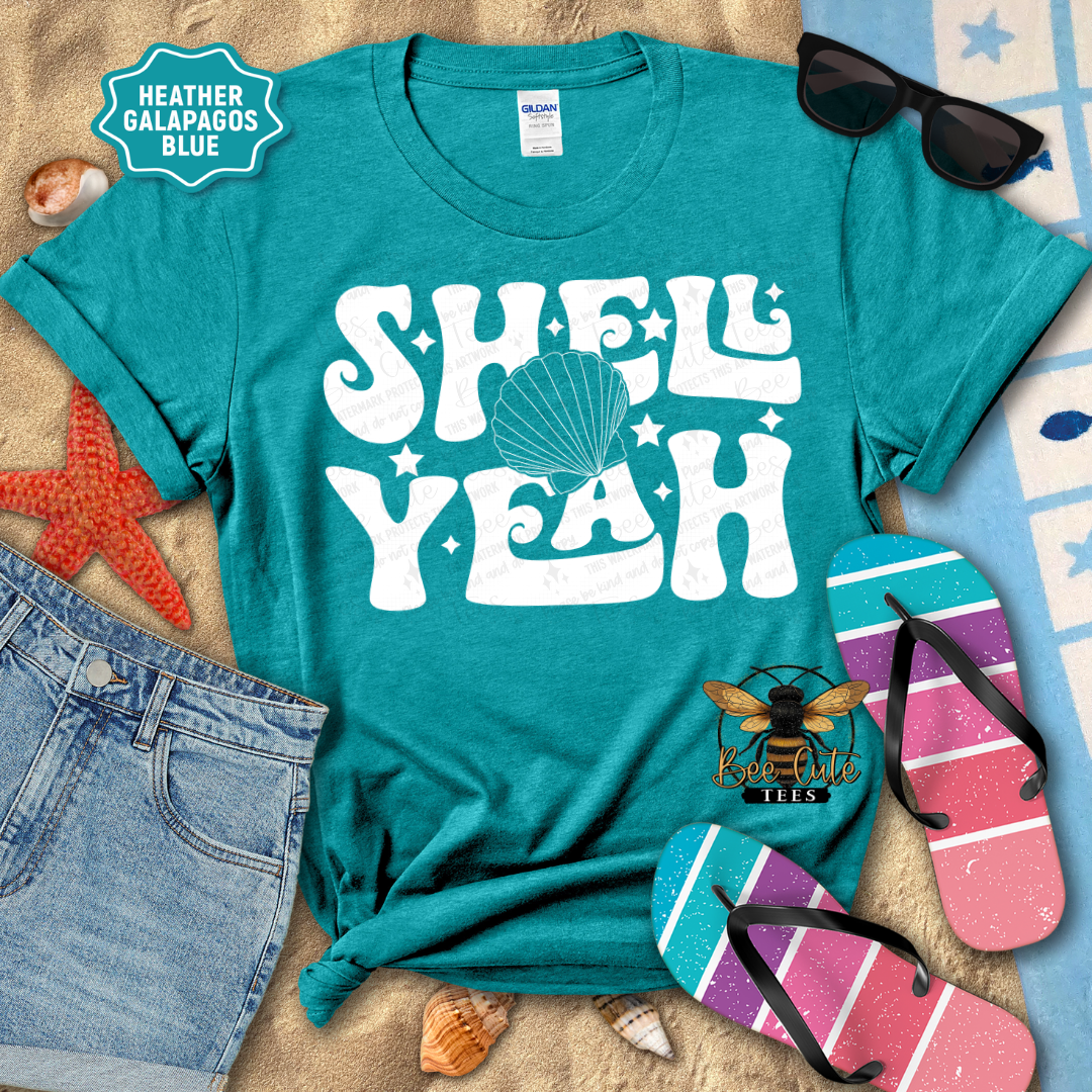 Teal t-shirt with 'Shell Yeah' design on a beach-themed background with sunglasses, flip-flops, and starfish.