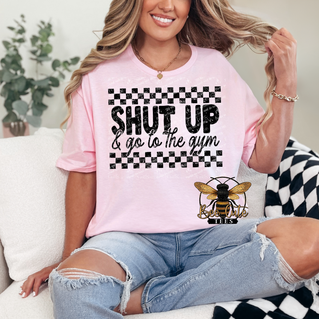 Person wearing a pink t-shirt with a bee logo and text, sitting on a couch.