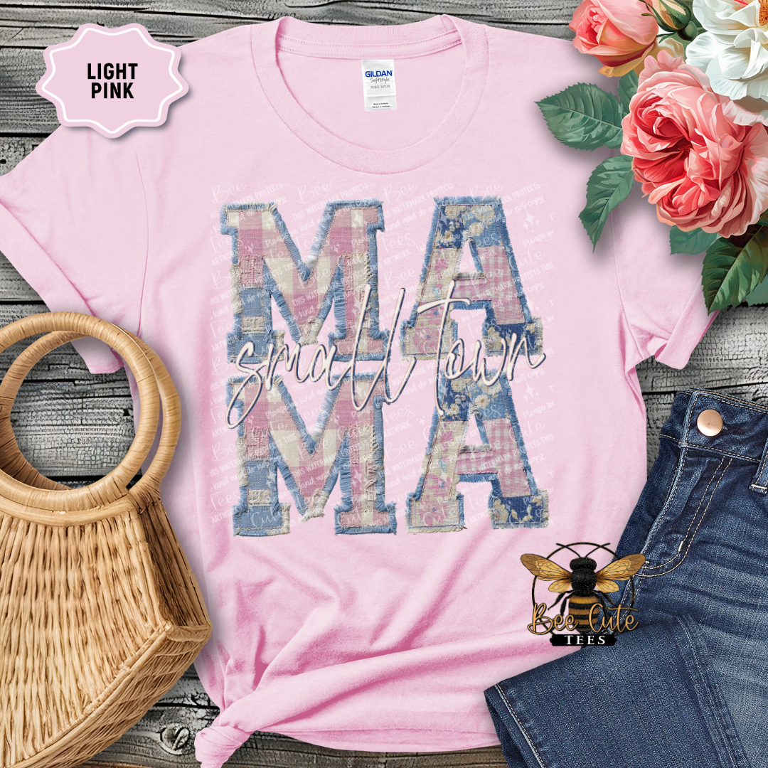 Light pink t-shirt with 'Mama' design on a wooden surface with flowers and denim jeans.