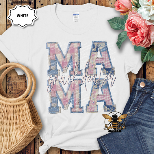 White t-shirt with 'MAMA' design on a wooden surface with flowers and denim jeans.