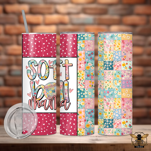 Three colorful tumblers with patterned designs on a wooden surface against a brick wall background.