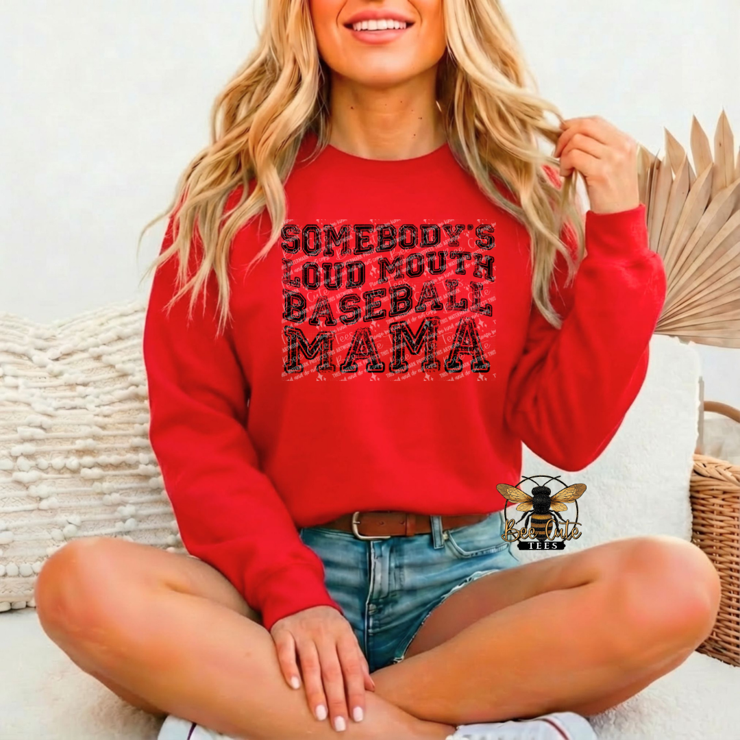 Woman wearing a red sweatshirt with text, sitting on a couch.
