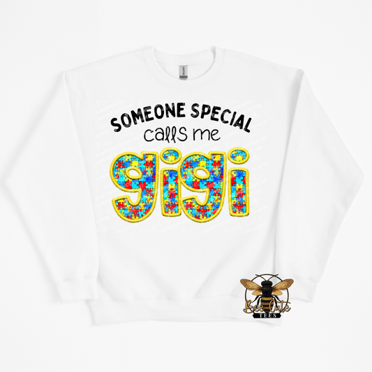 White sweatshirt with colorful text 'SOMEONE SPECIAL calls me GIGI' and a bee logo on a white background.