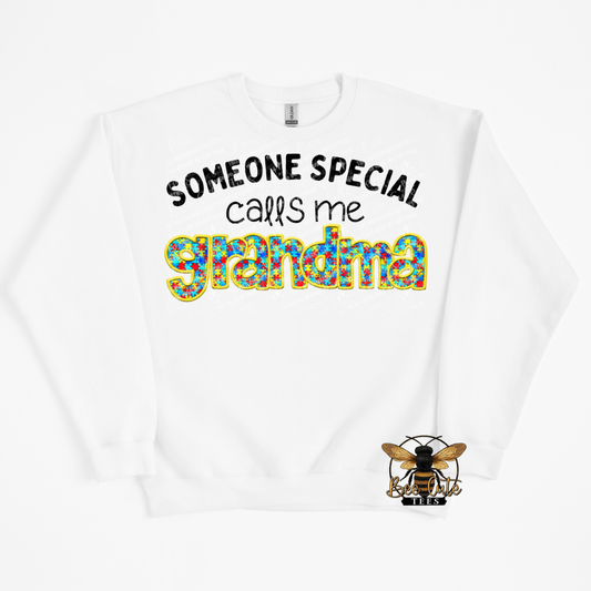 White sweatshirt with colorful text 'Someone special calls me grandma' and a bee logo on a white background