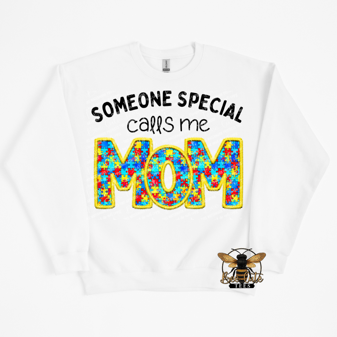 White sweatshirt with colorful 'MOM' text and bee logo on a white background