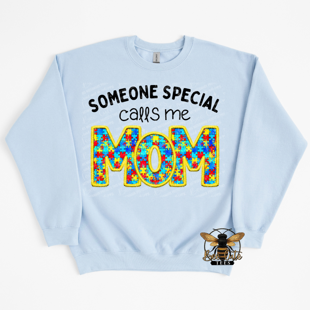 Light blue sweatshirt with colorful 'MOM' text and text 'Someone special calls me MOM' on a white background.