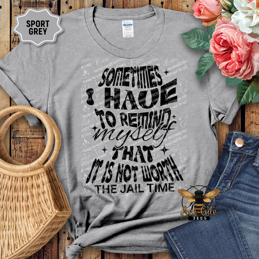 Gray t-shirt with a motivational quote on a wooden surface with flowers and jeans.