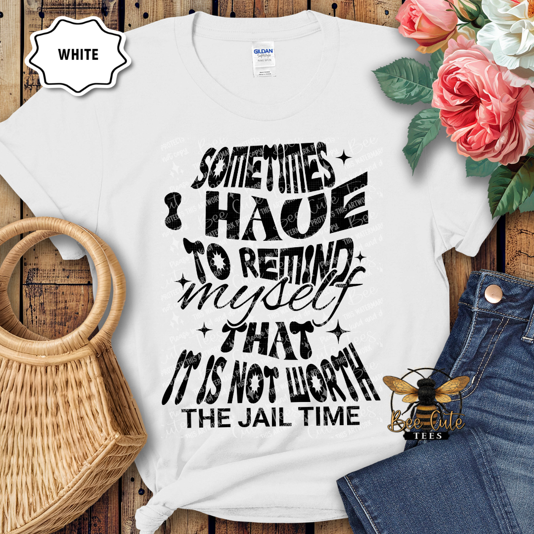 White t-shirt with humorous text design on a wooden surface with flowers and jeans.