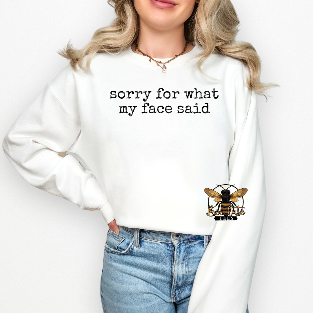 Person wearing a white sweatshirt with text and a bee logo on a plain background