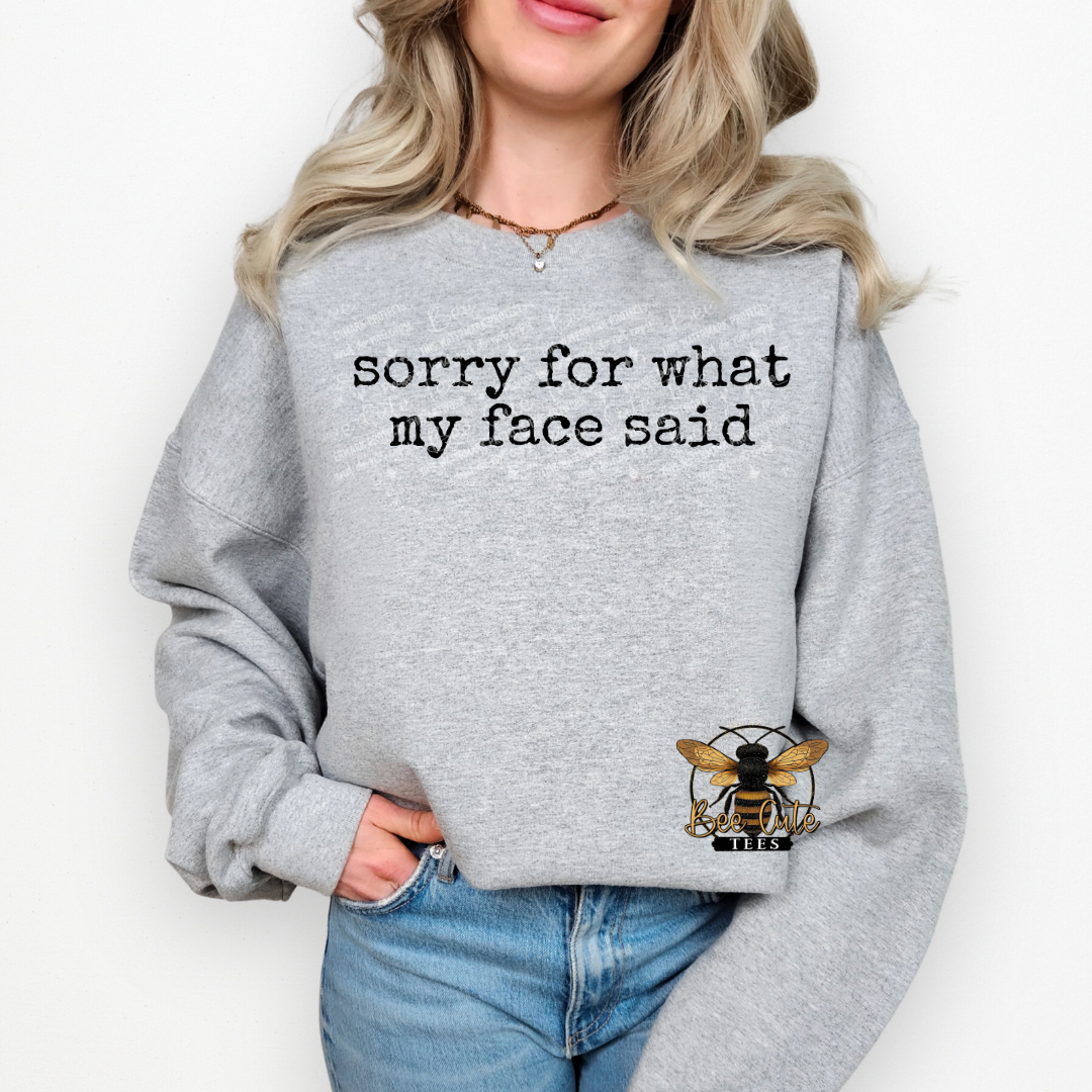 Person wearing a gray sweatshirt with text and a bee logo on a white background