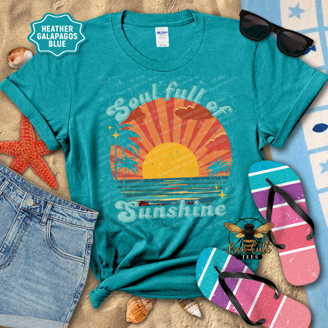 Teal t-shirt with 'Soul full of Sunshine' design on a beach-themed background with sunglasses, flip-flops, and denim shorts.