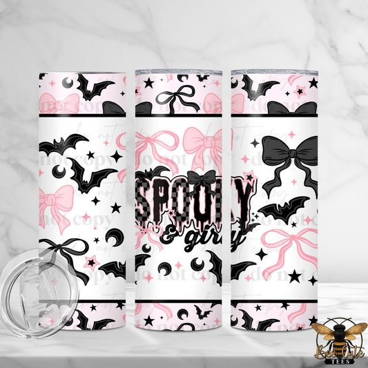 Three slim tumblers with a Halloween-themed pattern featuring black bats, pink bows, black moons, and stars on a white background. The center tumbler has the text 'SPOOKY girl' in a dripping font.