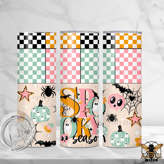 Three tall skinny tumblers with a pastel Halloween-themed washi tape pattern and spooky graphics, shown on a white marble surface with a clear lid in the foreground.