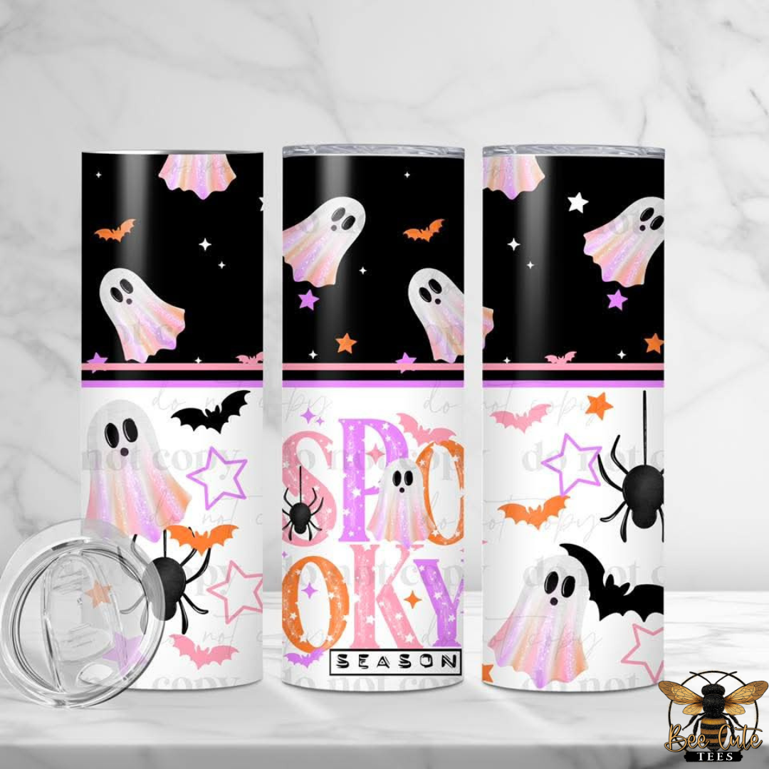 Three views of a Halloween-themed tumbler with a clear lid, featuring ghost, spider, bat, and star illustrations on a black and white background.