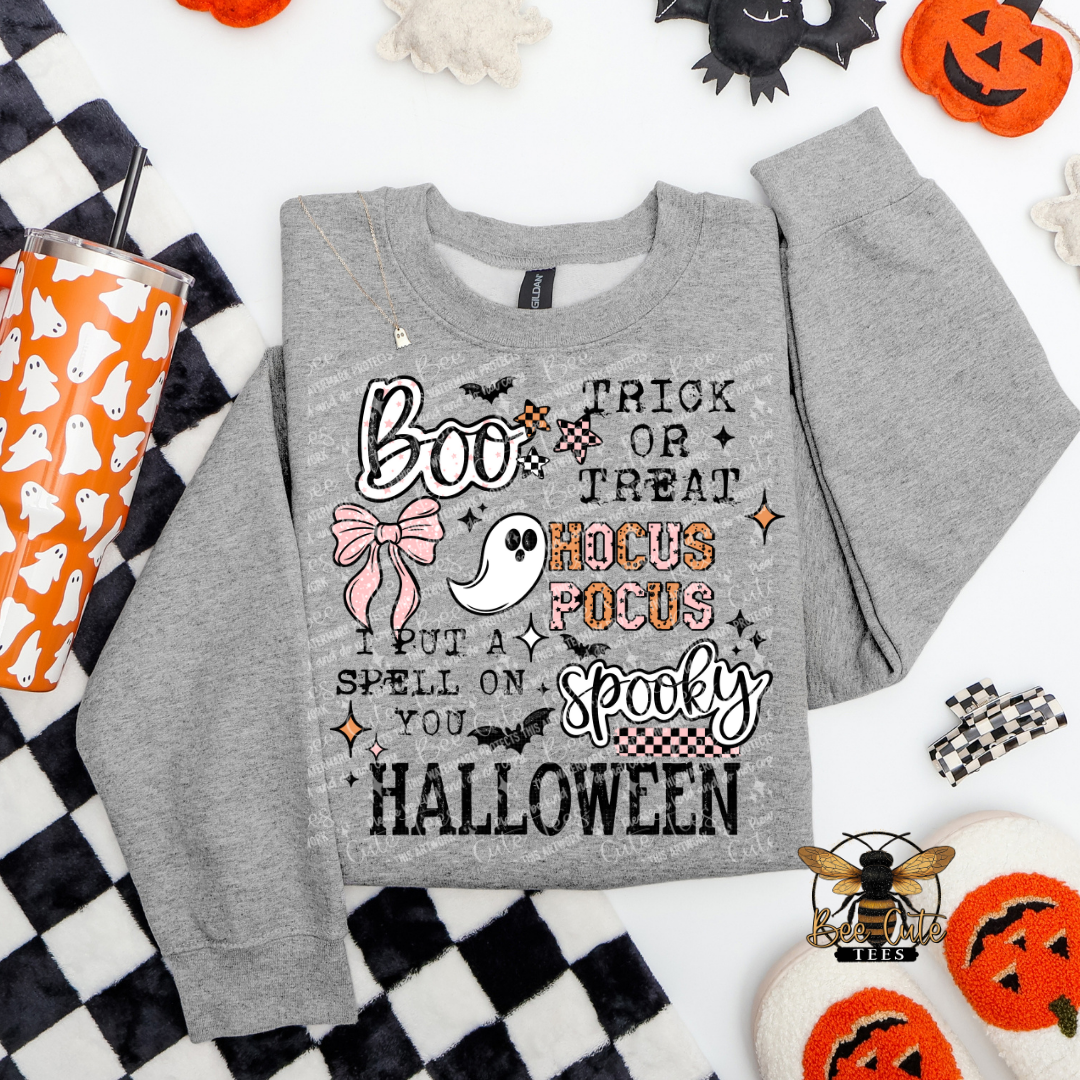 Gray sweatshirt with Halloween-themed text and graphics on a checkered background with Halloween decor.