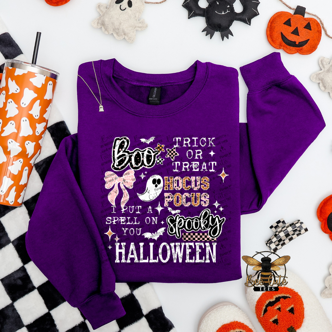 Purple Halloween-themed sweatshirt with text and graphics on a white background with Halloween decorations.