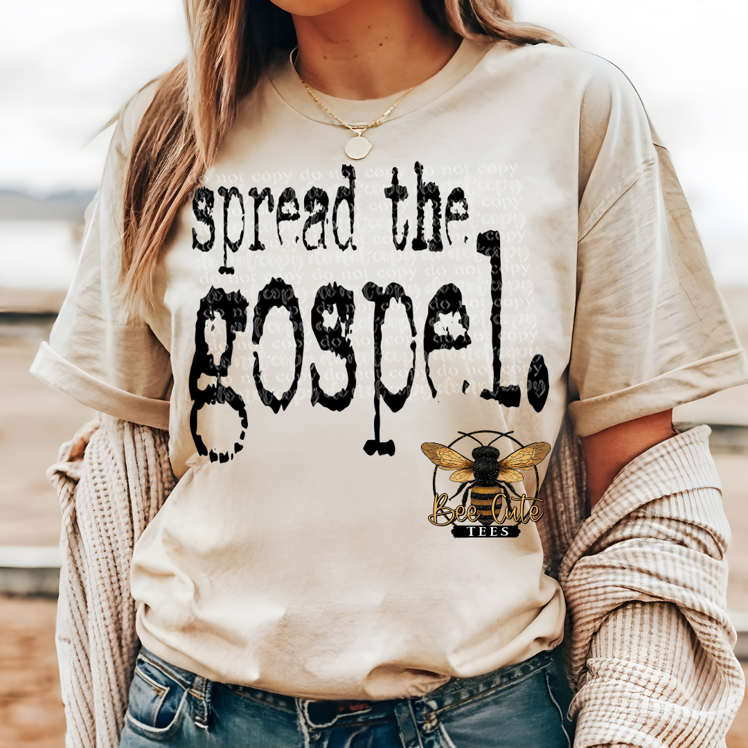 Person wearing a beige sweatshirt with 'spread the gospel' text and bee logo.