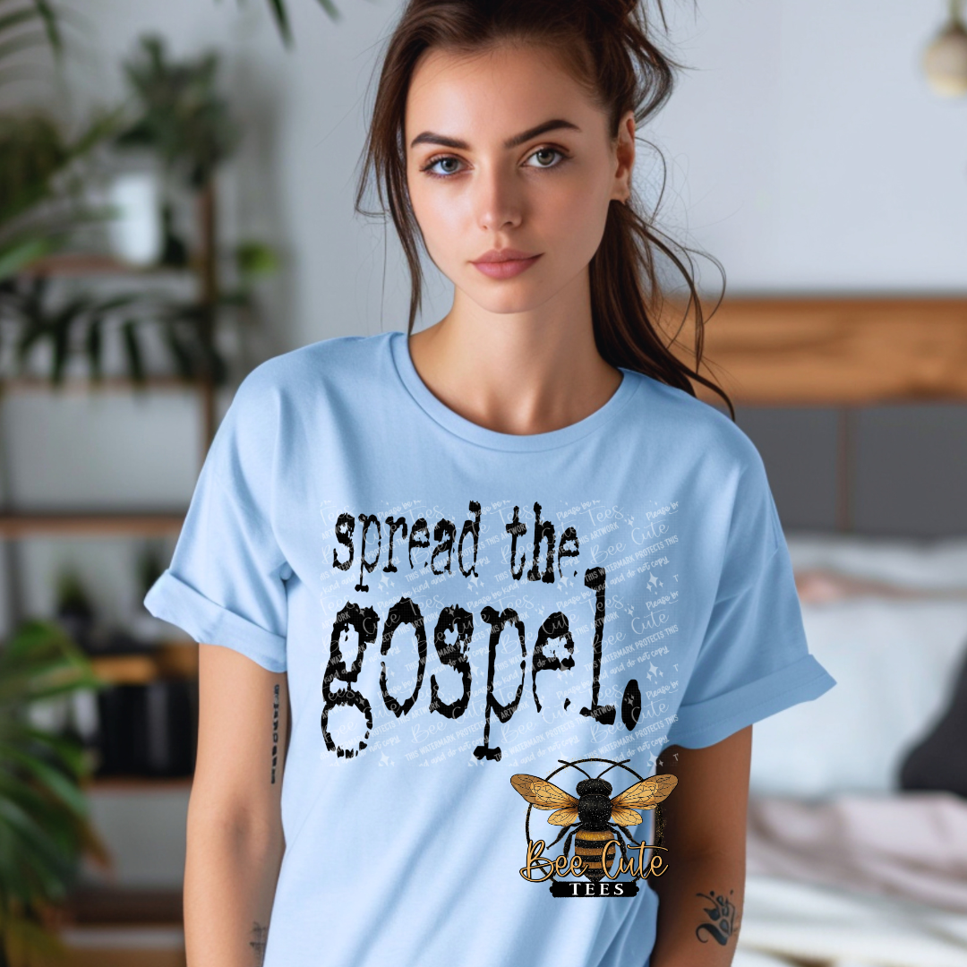 Woman wearing a light blue t-shirt with 'spread the gospel' text and a logo.