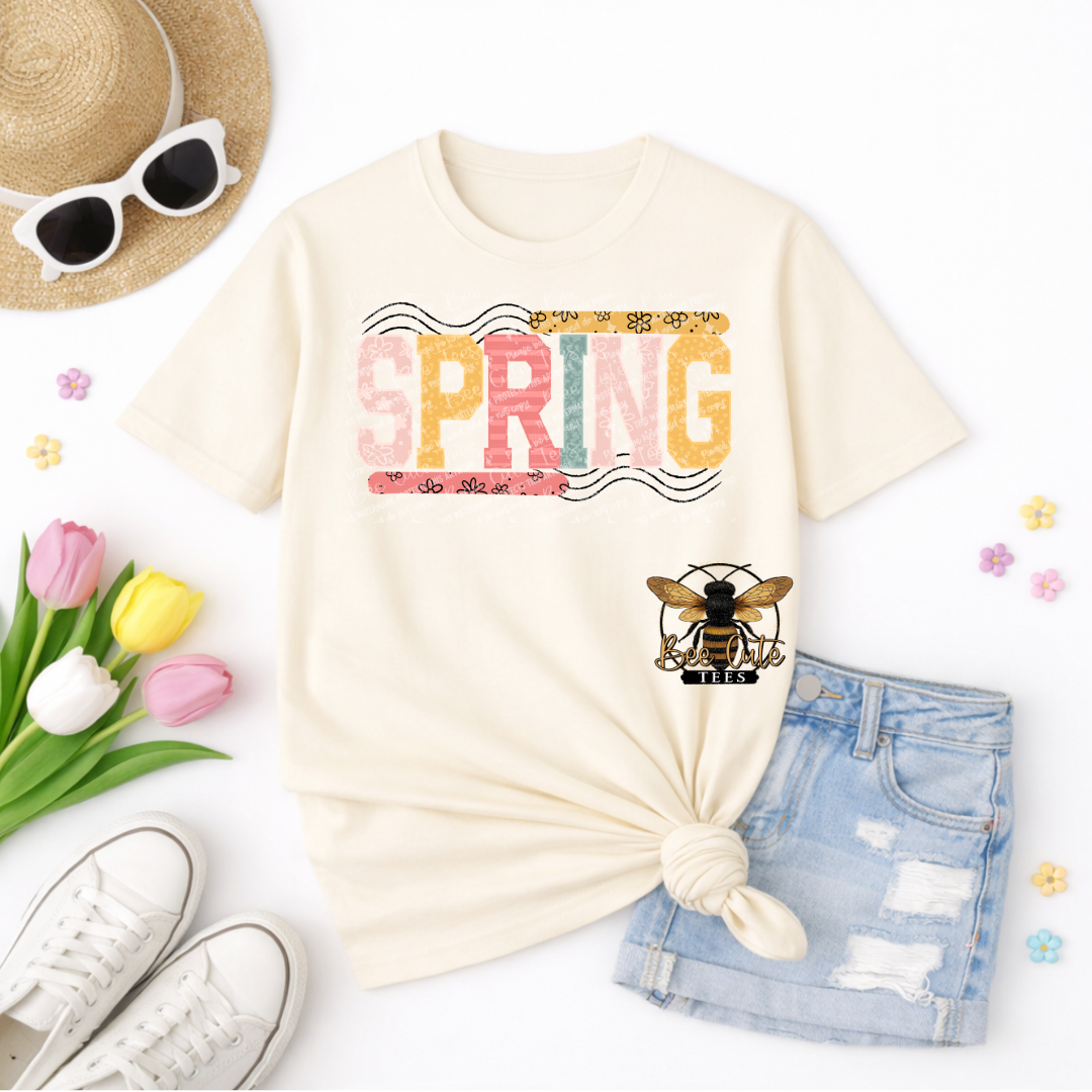 Beige t-shirt with 'SPRING' design, sunglasses, tulips, and denim shorts on a white background