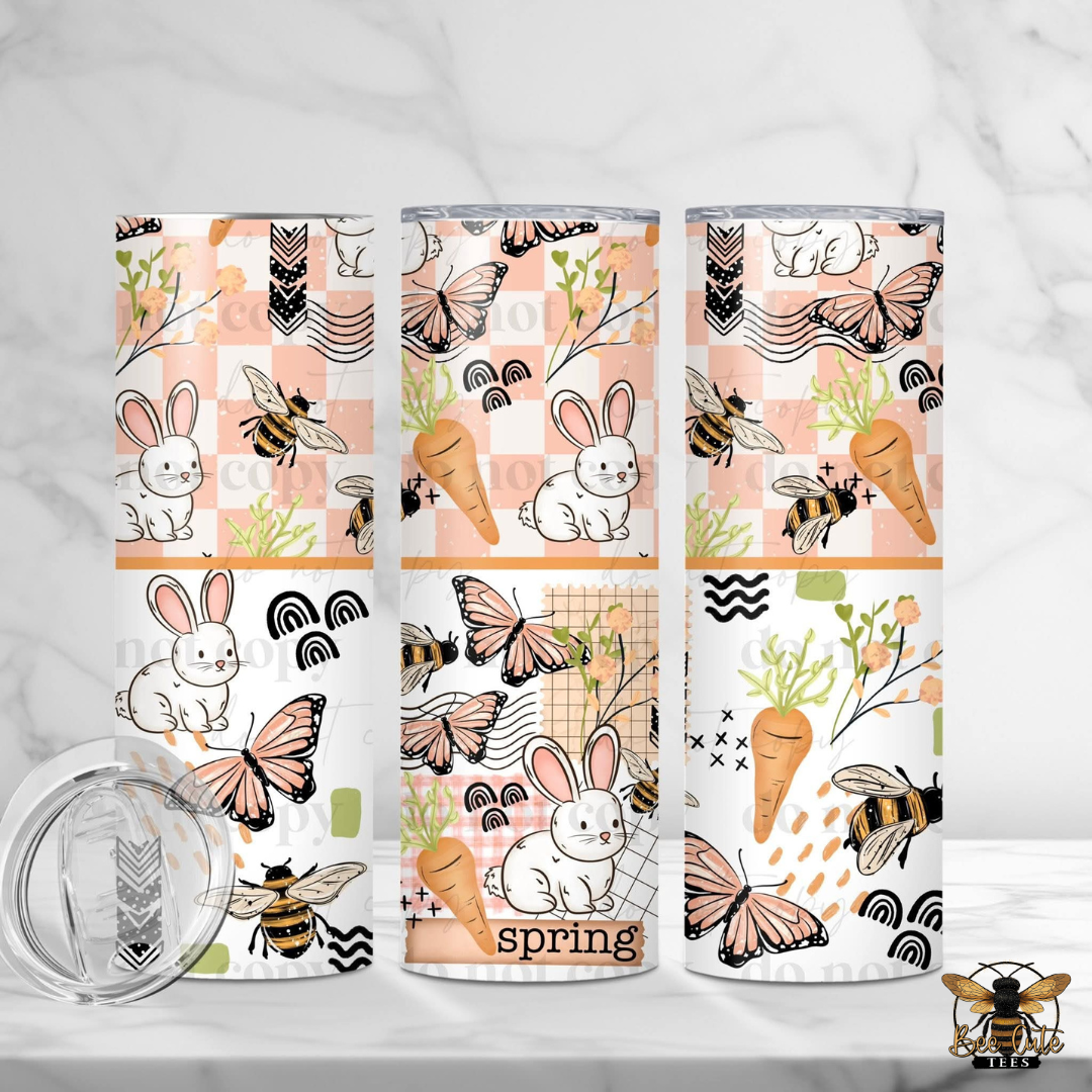 Three tumblers with spring-themed designs featuring bunnies, carrots, and butterflies on a white background.