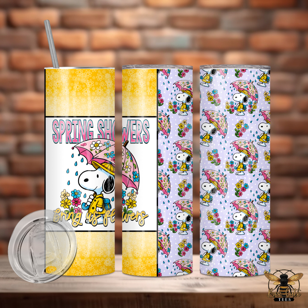 Two tumblers with a dog designs on a wooden surface against a brick wall background.