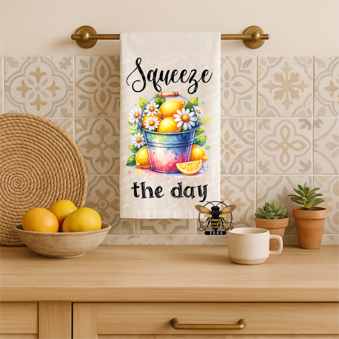 Kitchen towel with lemon design and text 'Squeeze the day' hanging on a towel rack.