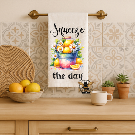 Kitchen towel with lemon design and text 'Squeeze the day' hanging on a towel rack.