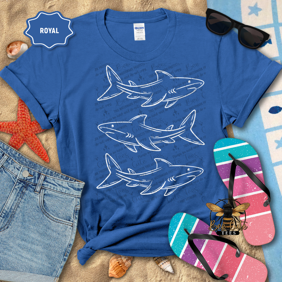 Blue t-shirt with shark designs on a beach-themed background